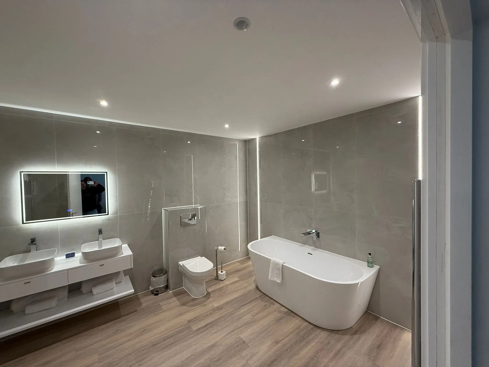 Modern bathroom with a freestanding bath and a white suite