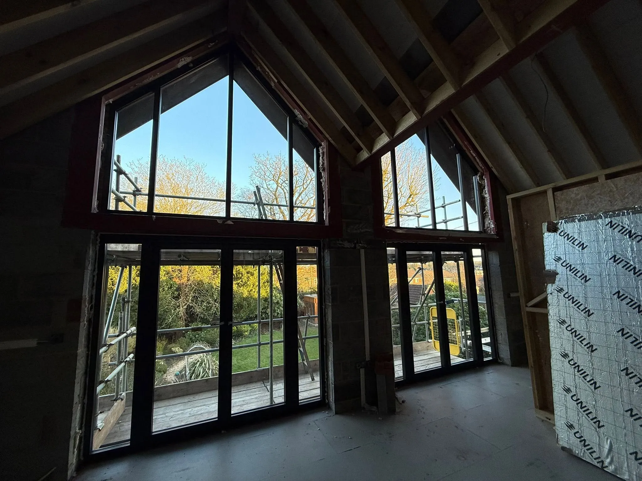 Vaulted room with full-height black aluminium windows and doors overlooking the garden