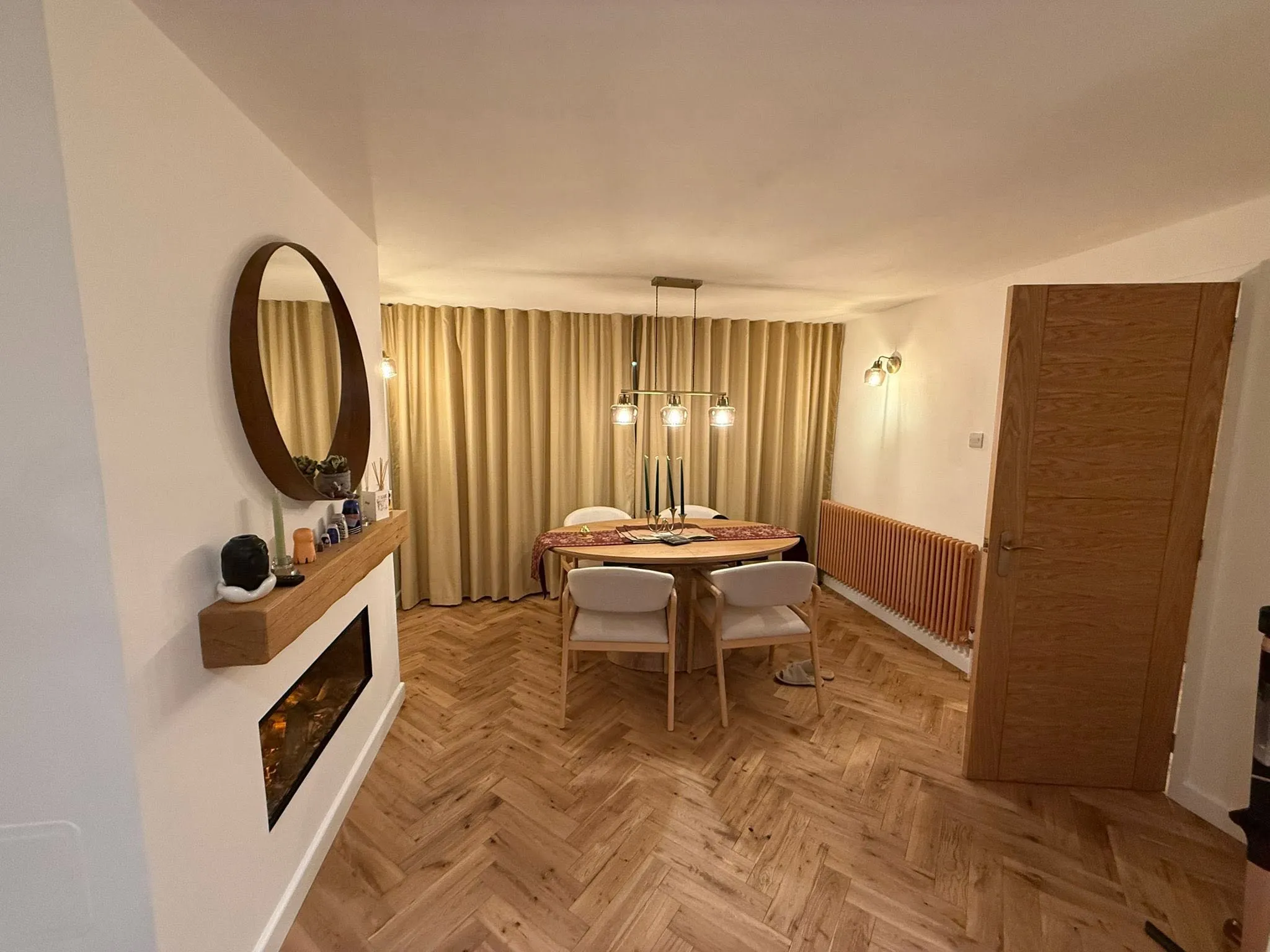 Dining room with herringbone flooring, a wall-mounted fire and a new oak internal door