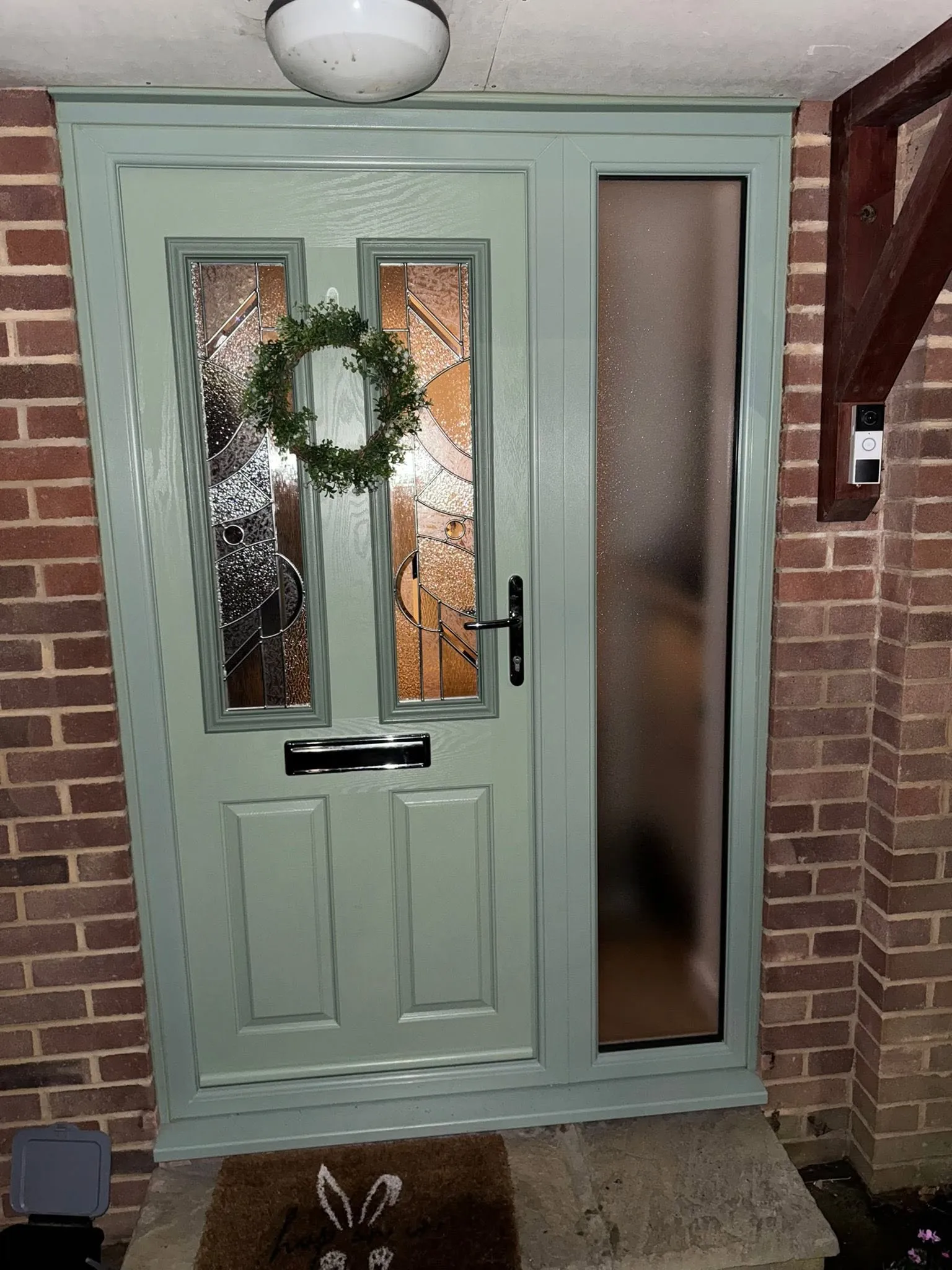 Sage green composite front door with leaded glazing and a matching glazed side panel