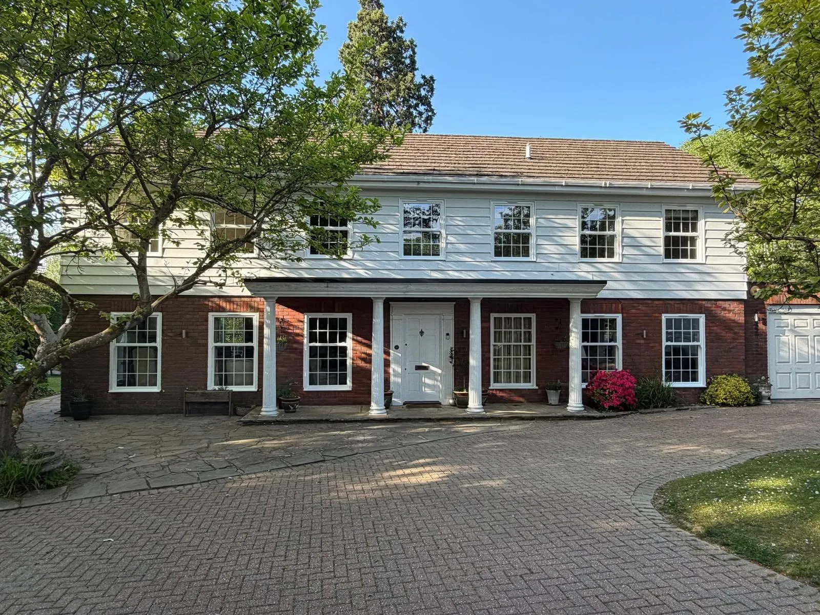 Detached Georgian-style house with a columned portico and new white sash windows with Georgian bars on both floors