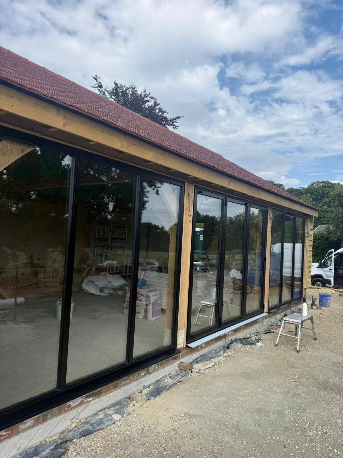 Large glazed garden room with dark frames looking onto a garden
