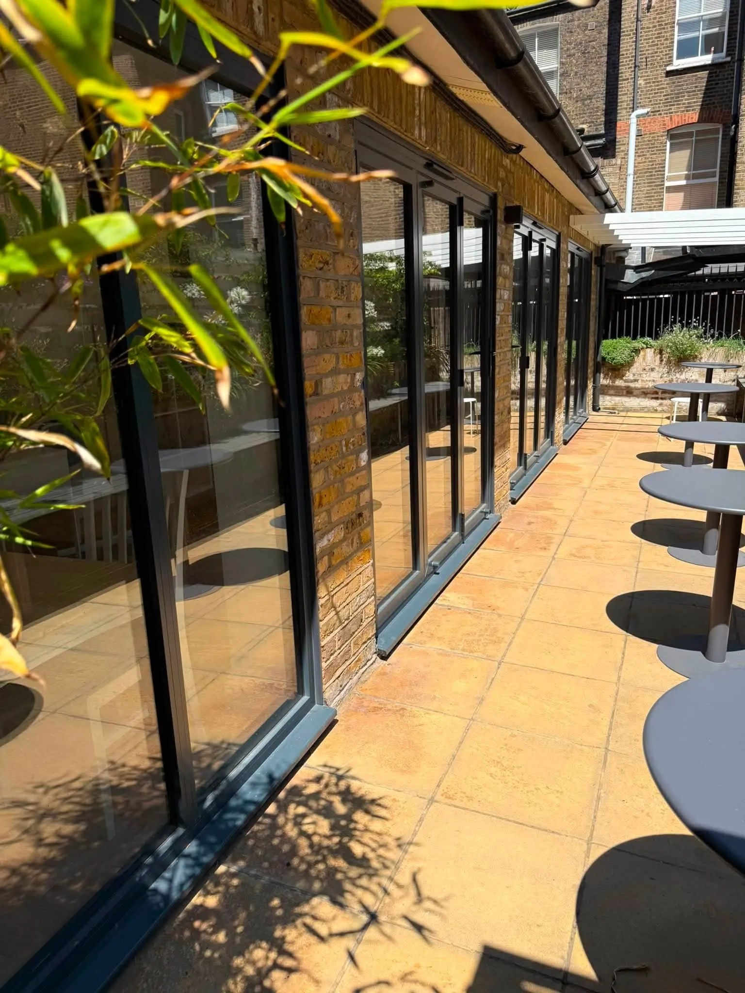 Glazed lean-to over a paved walkway alongside a house