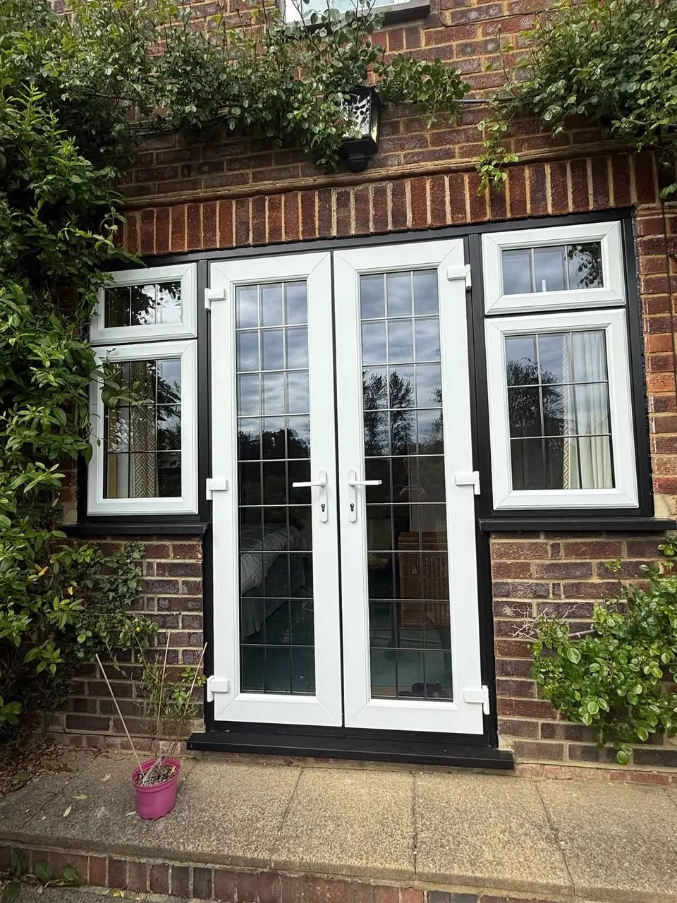 New white uPVC French doors with leaded glazing and matching side windows