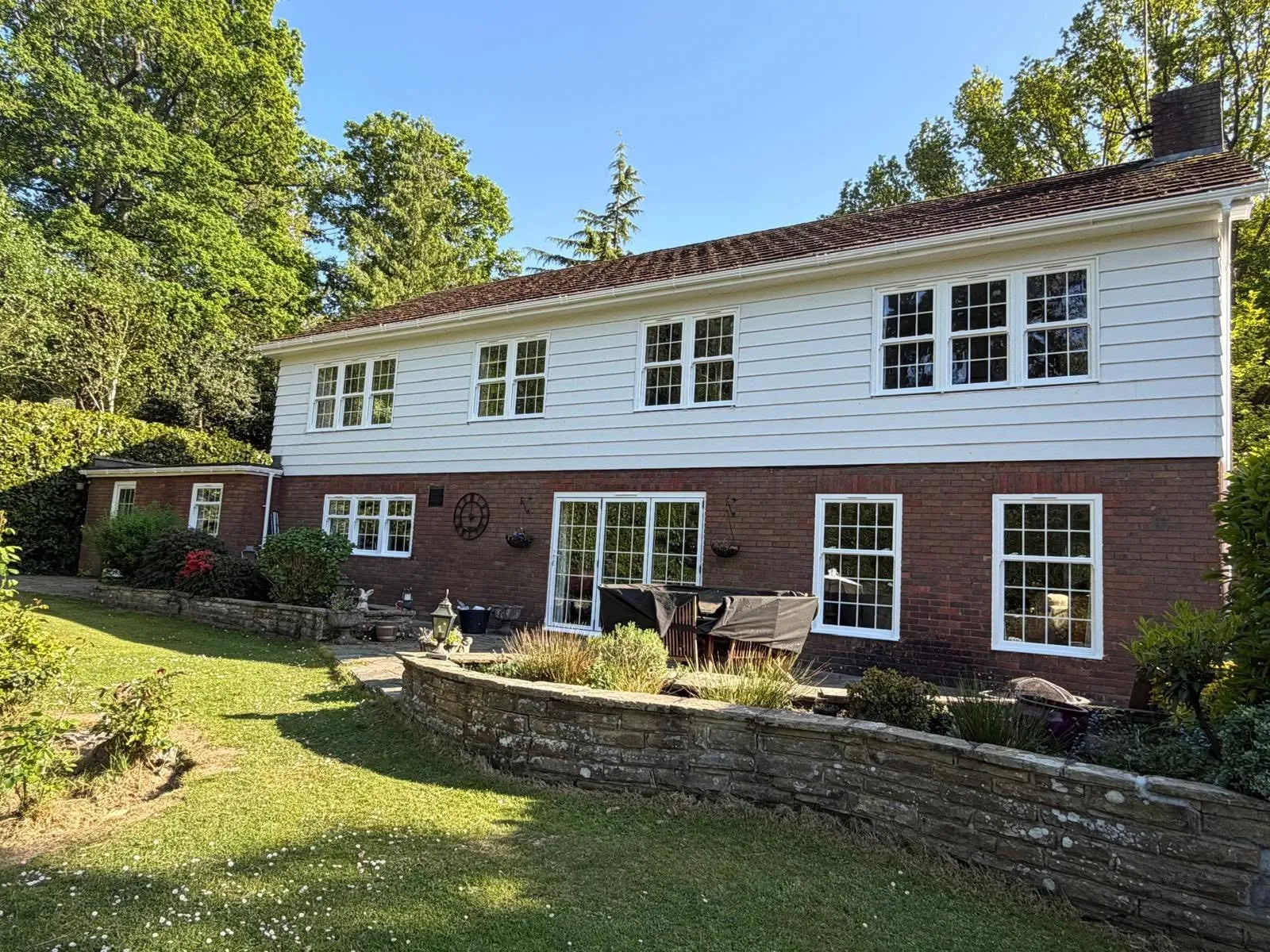 Replacement white uPVC casement windows fitted to a brick and weatherboard house in Sussex