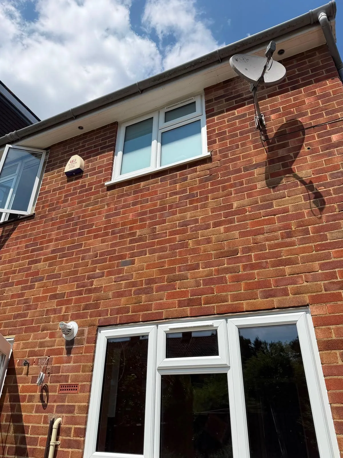 White uPVC windows and glazed doors on the rear elevation of a brick home